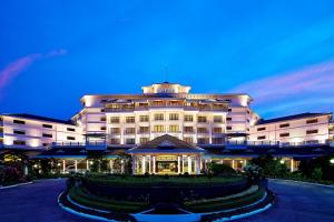 a hotel building with a garden in front of it at Le Meridien Kochi in Cochin