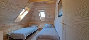 two beds in a small room with two windows at Orfűi Gomba Vendégház in Orfű