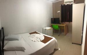 a bedroom with a bed and a desk with a computer at Hotel BLESS in Cascavel