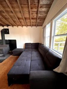 a living room with a black couch and a window at Archie's Lakeside Cabin in Wolfville