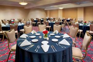 una sala de conferencias con una mesa con platos y servilletas en Four Points by Sheraton Melville Long Island, en Plainview