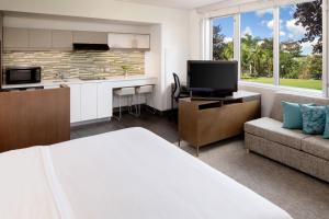 a room with a bed and a kitchen and a couch at Element Miami International Airport in Miami