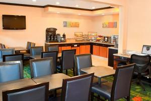 a dining room with tables and chairs and a kitchen at Fairfield Inn by Marriott Forsyth Decatur in Forsyth