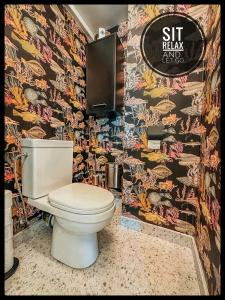 a bathroom with a toilet and a colorful wall at CASA MARE hartje Oostende met gratis parking in Ostend