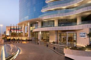 a large office building with a circular driveway in front of it at Le Meridien Riyadh in Riyadh