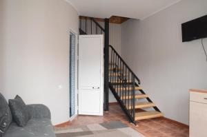 a staircase in a room with a couch and a television at Guest House Fairy Tale in Kaji-Say +49 photos