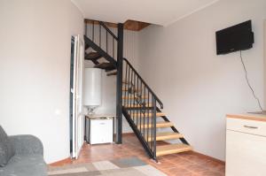 a spiral staircase in a living room with a tv at Guest House Fairy Tale in Kaji-Say