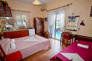 a bedroom with a bed and a kitchen with a table at Ikaria Studios in Manganítis