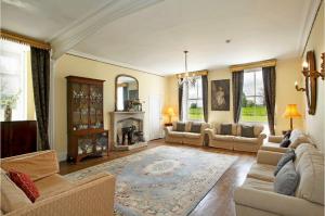 a living room with couches and a fireplace at Newcourt Manor in Hereford
