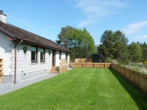 a large yard with a fence and a house at Tanleys Guesthouse in Grantown on Spey