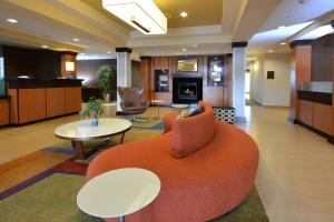 a hotel lobby with an orange couch and tables at Fairfield Inn & Suites Wytheville in Wytheville