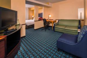 una camera d'albergo con TV, divano e letto di Fairfield Inn Dulles Airport Chantilly a Chantilly