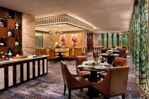 a restaurant with tables and chairs and a bar at JW Marriott Hotel Chengdu in Chengdu