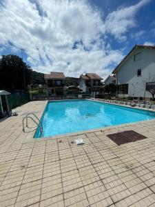 Chalet en urbanización con piscina في أرغونيوس: مسبح ازرق كبير امام المنزل