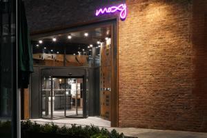 un’insegna al neon sul lato di un edificio in mattoni di Moxy Manchester City a Manchester