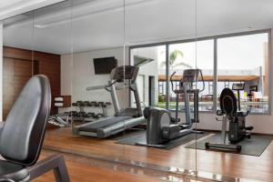 een fitnessruimte met loopbanden en crosstrainers en een grote spiegel bij Four Points By Sheraton Le Verdun in Beiroet