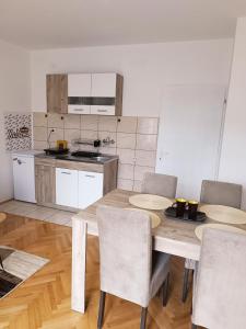 a kitchen with a table and chairs in a room at Apartman HeLena in Soko Banja