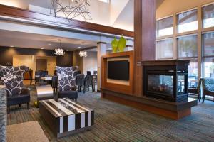 a living room with a fireplace and a dining room at Residence Inn Gainesville I-75 in Gainesville