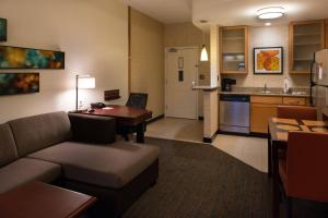 a living room with a couch and a table and a kitchen at Residence Inn Gainesville I-75 in Gainesville
