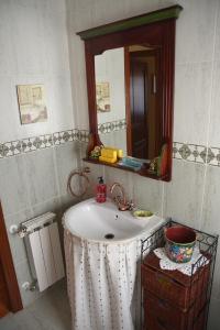 een badkamer met een wastafel en een spiegel bij Chalet en urbanización con piscina in Argoños