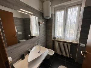 a bathroom with a sink and a toilet and a mirror at B&B La Magnolia in Caprino Veronese +39 photos