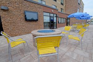 un grupo de sillas amarillas, una mesa y una sombrilla en Fairfield Inn & Suites by Marriott Bowling Green, en Bowling Green