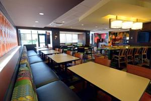 a restaurant with tables and chairs and a bar at Fairfield Inn & Suites by Marriott Bowling Green in Bowling Green