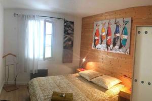 a bedroom with a bed and a picture of surfboards on the wall at Entre mer et forêt, idéalement située in Rivedoux-Plage
