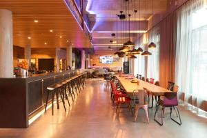 a restaurant with tables and chairs and a bar at Moxy Berlin Ostbahnhof in Berlin