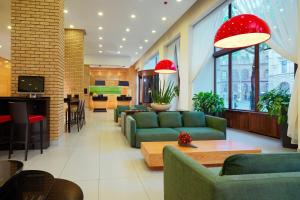a living room with green couches and a table at Courtyard by Marriott Budapest City Center in Budapest