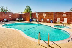 une grande piscine en face d'un bâtiment en briques dans l'établissement SpringHill Suites by Marriott Dallas Richardson/Plano, à Richardson