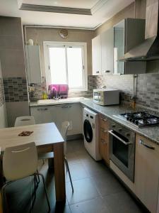 a kitchen with a table and a stove top oven at luxe & VIP appartement a côté de tunsia mall lac 2 in Tunis
