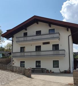 een groot wit gebouw met een bank ervoor bij Lärchenheim Appartment in Castelrotto
