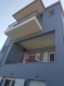 un edificio blanco con un balcón con sillas. en Eva's apartments, en Nafpaktos