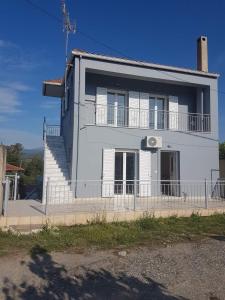 una casa blanca con una escalera delante en Eva's apartments en Nafpaktos