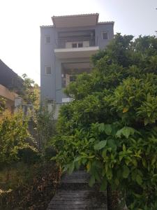 un edificio con una escalera delante de un árbol en Eva's apartments en Nafpaktos
