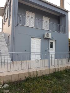 uma casa azul com varanda e escadas em Eva's apartments em Lepanto