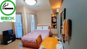 大阪市にあるアズガ－デン日本橋のベッドとテーブルが備わる小さな客室です。