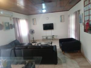 sala de estar con sofá y TV en Spintex Villas - Available for Long Term Rentals, en Ablekuma
