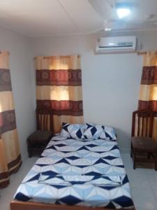 a bedroom with a bed and two chairs at Spintex Villas - Available for Long Term Rentals in Ablekuma