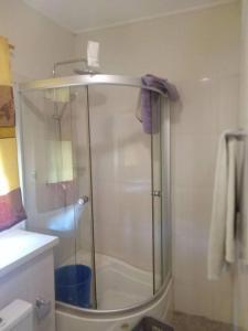 y baño con ducha y puerta de cristal. en Spintex Villas - Available for Long Term Rentals, en Ablekuma