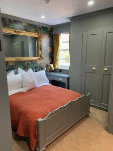 a bedroom with a bed with a red blanket and a mirror at Shelbourne House in Harrogate