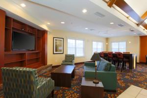 sala de estar con sillas y TV de pantalla plana en Residence Inn by Marriott Fort Smith en Massard