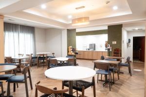 a restaurant with tables and chairs and a woman in a kitchen at Fairfield Inn & Suites Denton in Denton