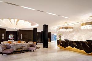 a lobby with a table and chairs and chandeliers at The Alexander, a Luxury Collection Hotel, Yerevan in Yerevan
