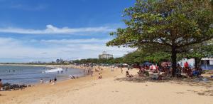 a group of people on a beach with a tree at Ap 305 Praia Castelhanos in Anchieta
