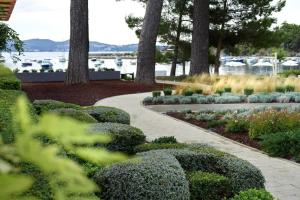 a walkway through a garden with bushes and trees at Sheraton Dubrovnik Riviera Hotel in Mlini