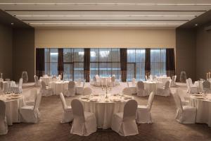 a ballroom with white tables and chairs and windows at Sheraton Dubrovnik Riviera Hotel in Mlini +102 photos