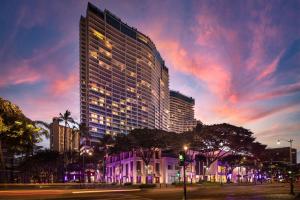 a tall building with lights on in a city at The Ritz-Carlton Residences, Waikiki Beach Hotel in Honolulu