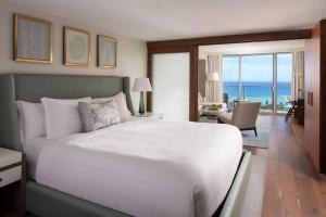 a bedroom with a large white bed with a view of the ocean at The Ritz-Carlton Residences, Waikiki Beach Hotel in Honolulu
